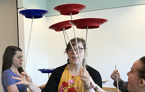 Librarians working together to balance multiple spinning plates.